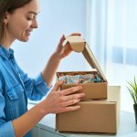 A loyal customer opening her package with personalized touches and a joyful smile.