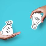 Two hands holding paper symbols of a bag of money and a lightbulb, against a teal background.