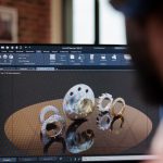 A product developer at a double monitor computer screen working on a prototype with a design software.