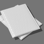 Two empty, white insulated mailers sit on a plain dark-gray background. The mailers are stacked on top of each other.