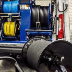 Professional drain-cleaning van interior with hose reels and tools neatly organized, ready for industrial plumbing work.