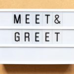 A white text display lightbox with black letters on translucent plastic spelling out the phrase "Meet & Greet".