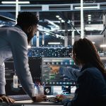 Data center team reviewing server performance data, with engineers analyzing systems in a high-tech control room.