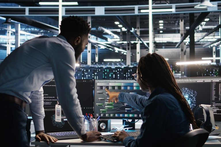 Data center team reviewing server performance data, with engineers analyzing systems in a high-tech control room.