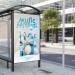 A bus transit shelter in an urban area displays a large poster of a music festival featuring various instruments.