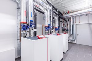A behind the scenes look at a building's heating room. The system has three separate heat pumps and pipework.
